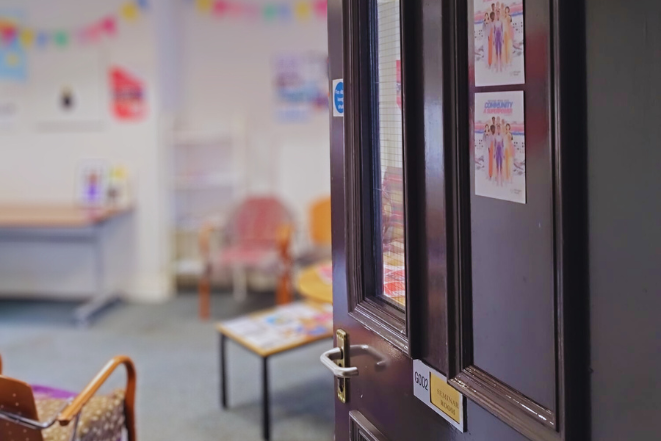 Door opening into a room with chairs and multiethnic soft furnishing