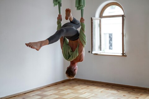 Person doing acrobatics in straps hanging from ceiling