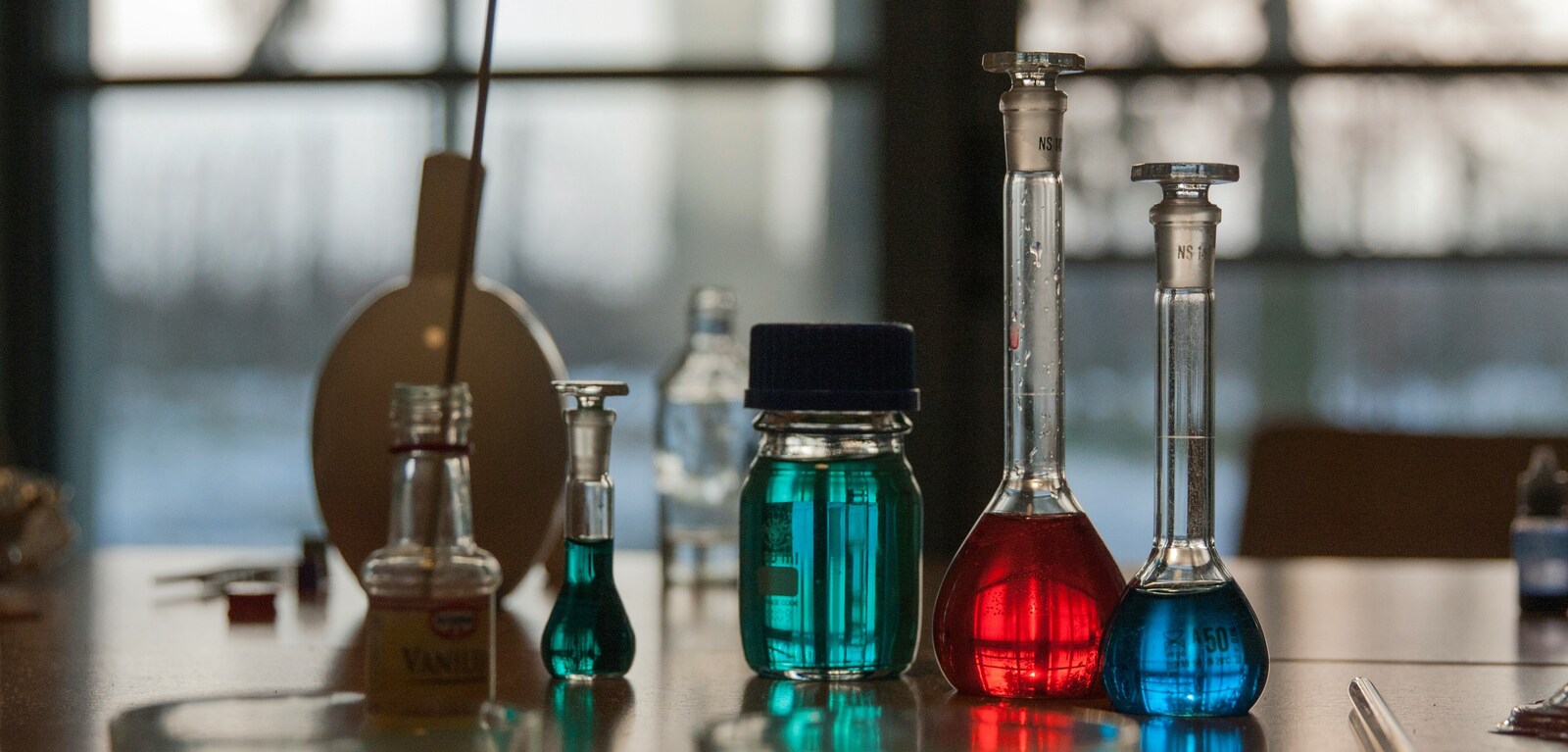 Glass test tubes and vials filled with coloured liquid