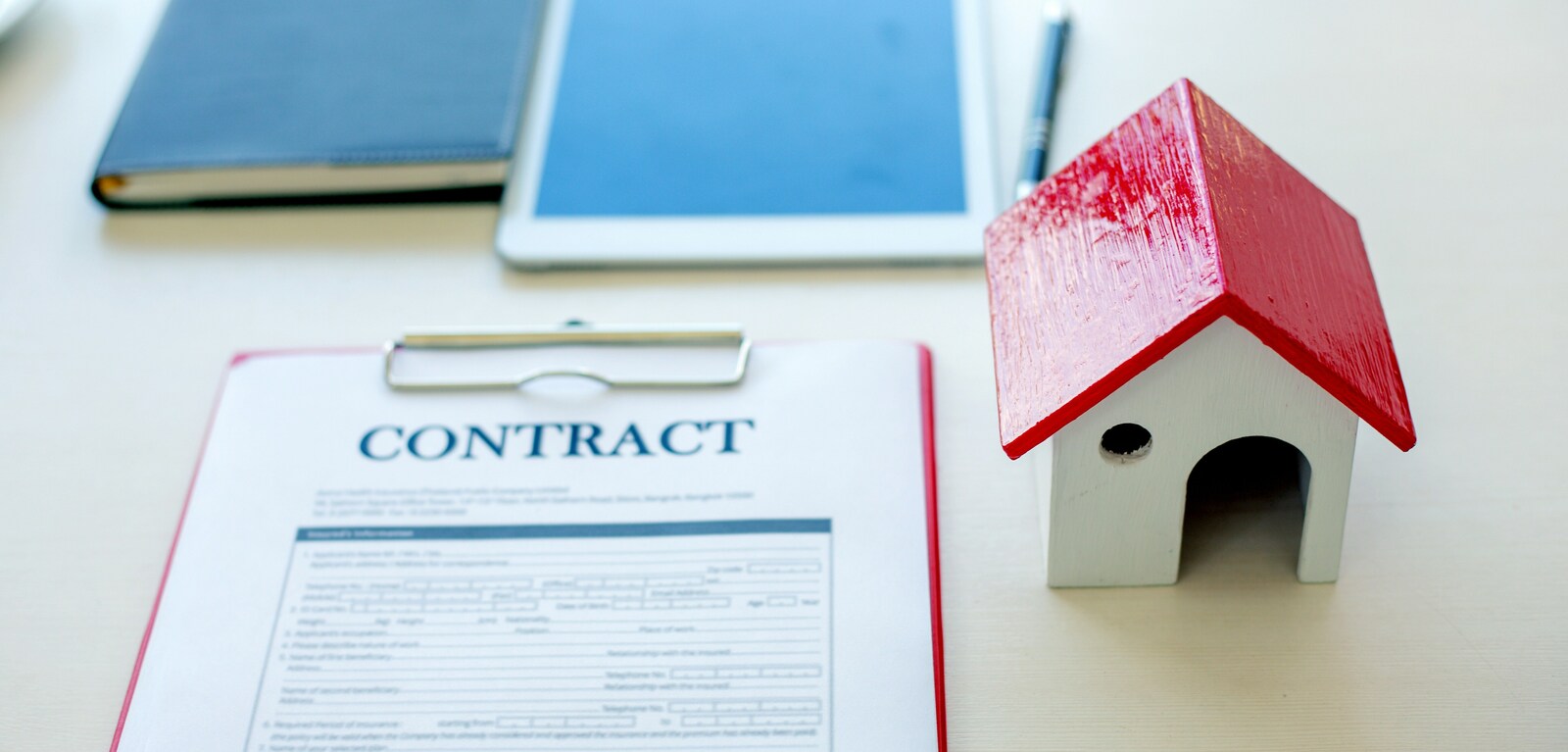 House contract beside small model of house