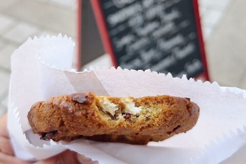 Student holding cookie in white paper bag outside Junction Cafe