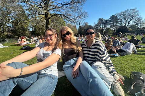 Student Martyna sits beside two friends in Botanic Gardens