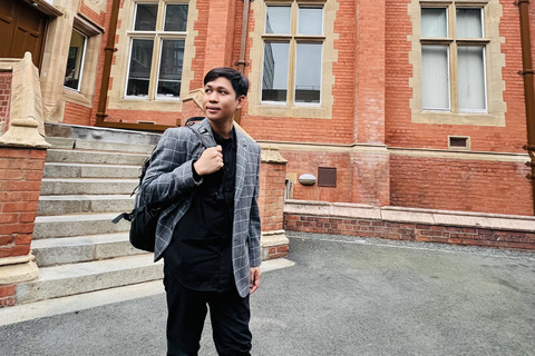 Student Muhammad stands outside building on campus