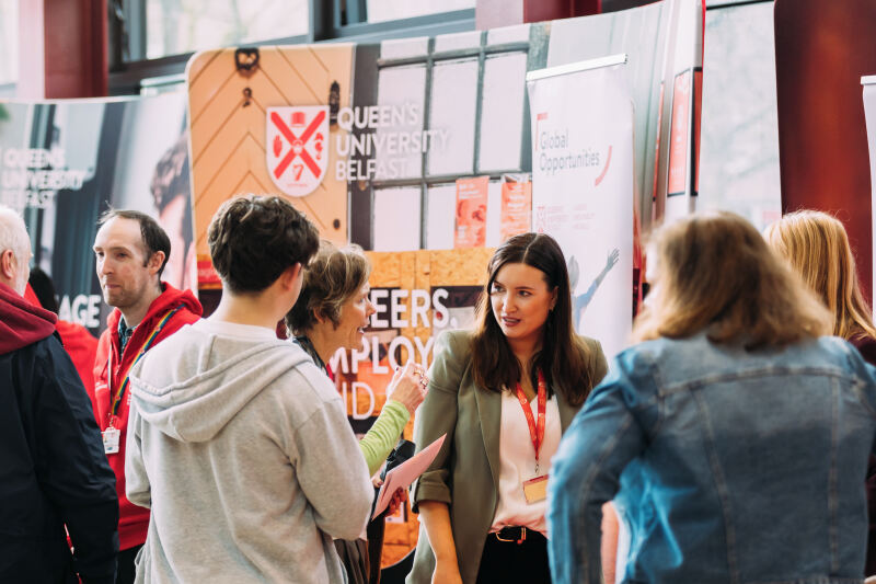 Students chatting to staff member at stall at offer holder day