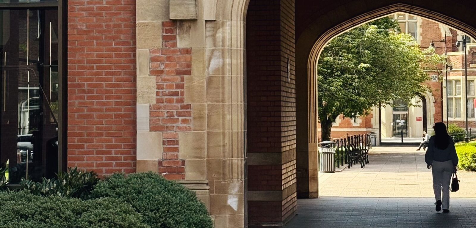 Student walking under arch in the Quad