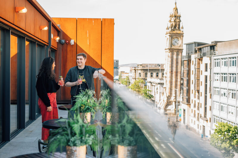Two students standing on rooftop bar