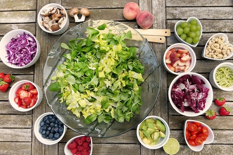 Bowls of salad and vegetables on top of table