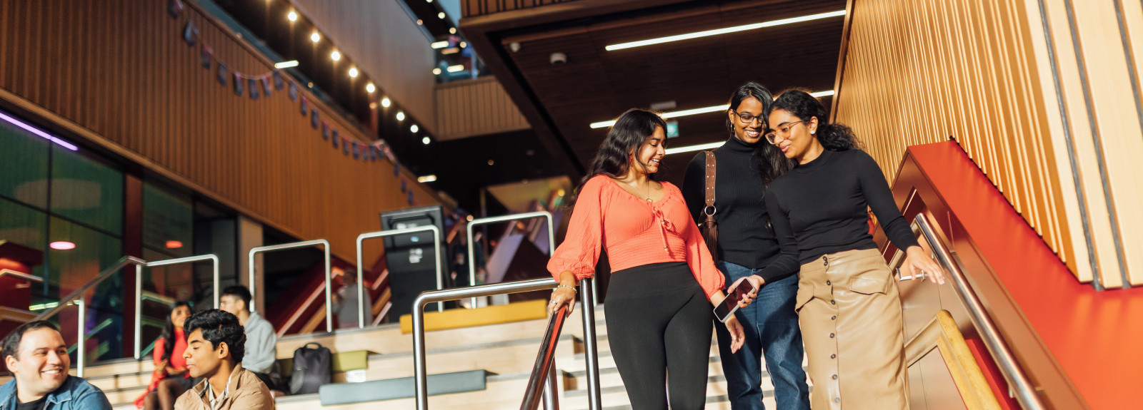 Three students walking downstairs in One Elmwood