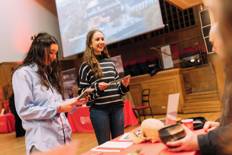 Two students talk to academic at offer holder event