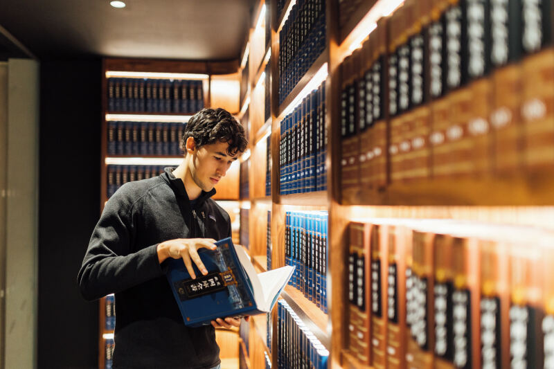 Student Lucas looks through book in the McClay Library